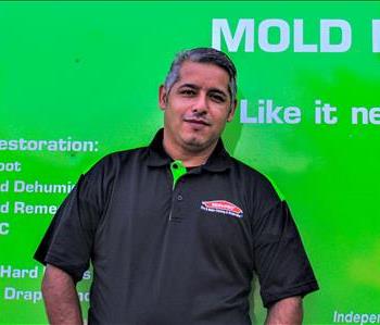 Man in SERVPRO uniform standing in front of a SERVPRO truck
