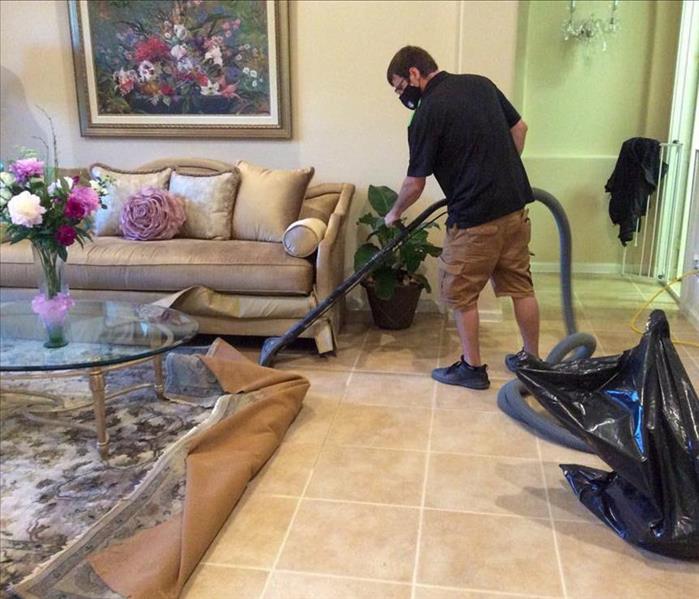 SERVPRO technician removing water from the floor of a Deerfield Beach home